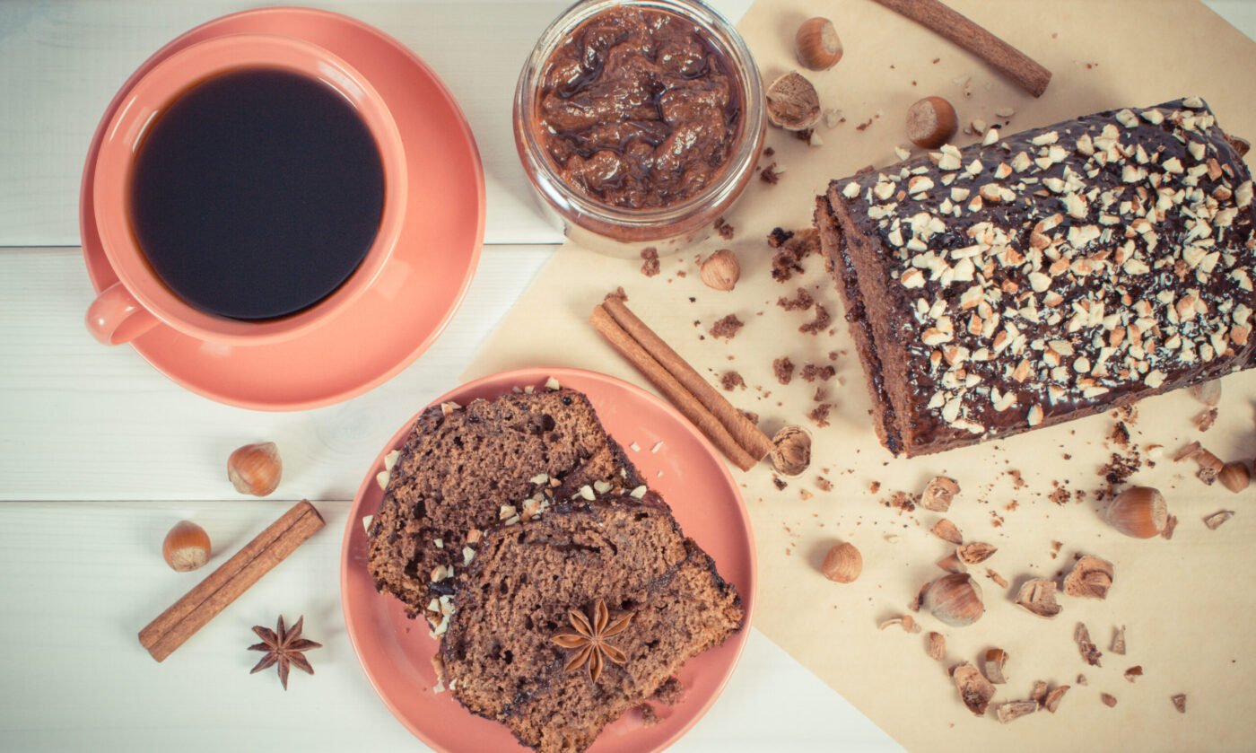 Vintage photo, Fresh baked gingerbread or dark cake with cocoa, chocolate and plum jam, cup of black coffee, delicious dessert